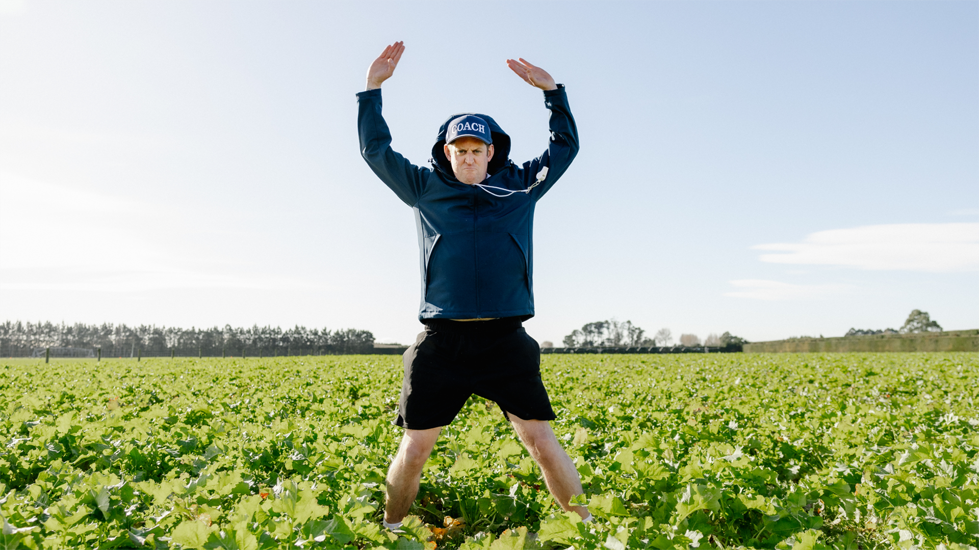 Person doing star jumps in middle of field of crops