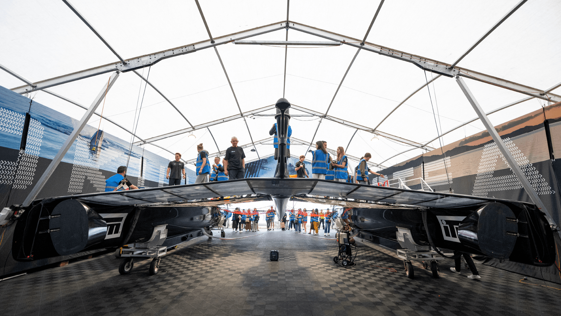 Boat crew inside tent setting up Sail GP boat