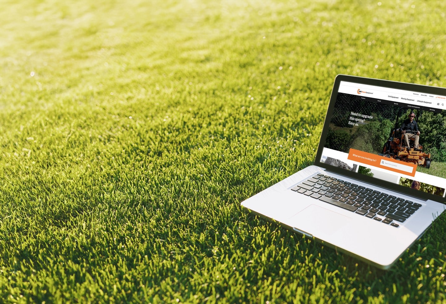Laptop on lawn with OMC website visual